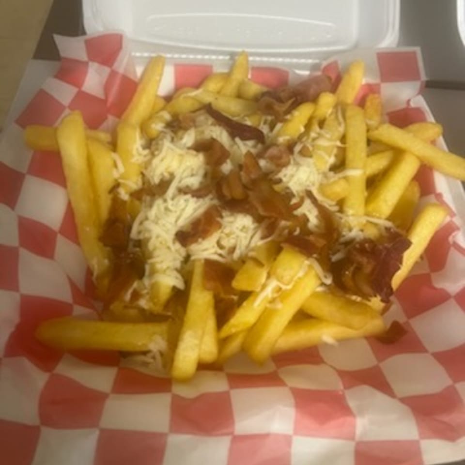 Pappy J's loaded fries with melted cheese and bacon bits in a red and white checkered paper.